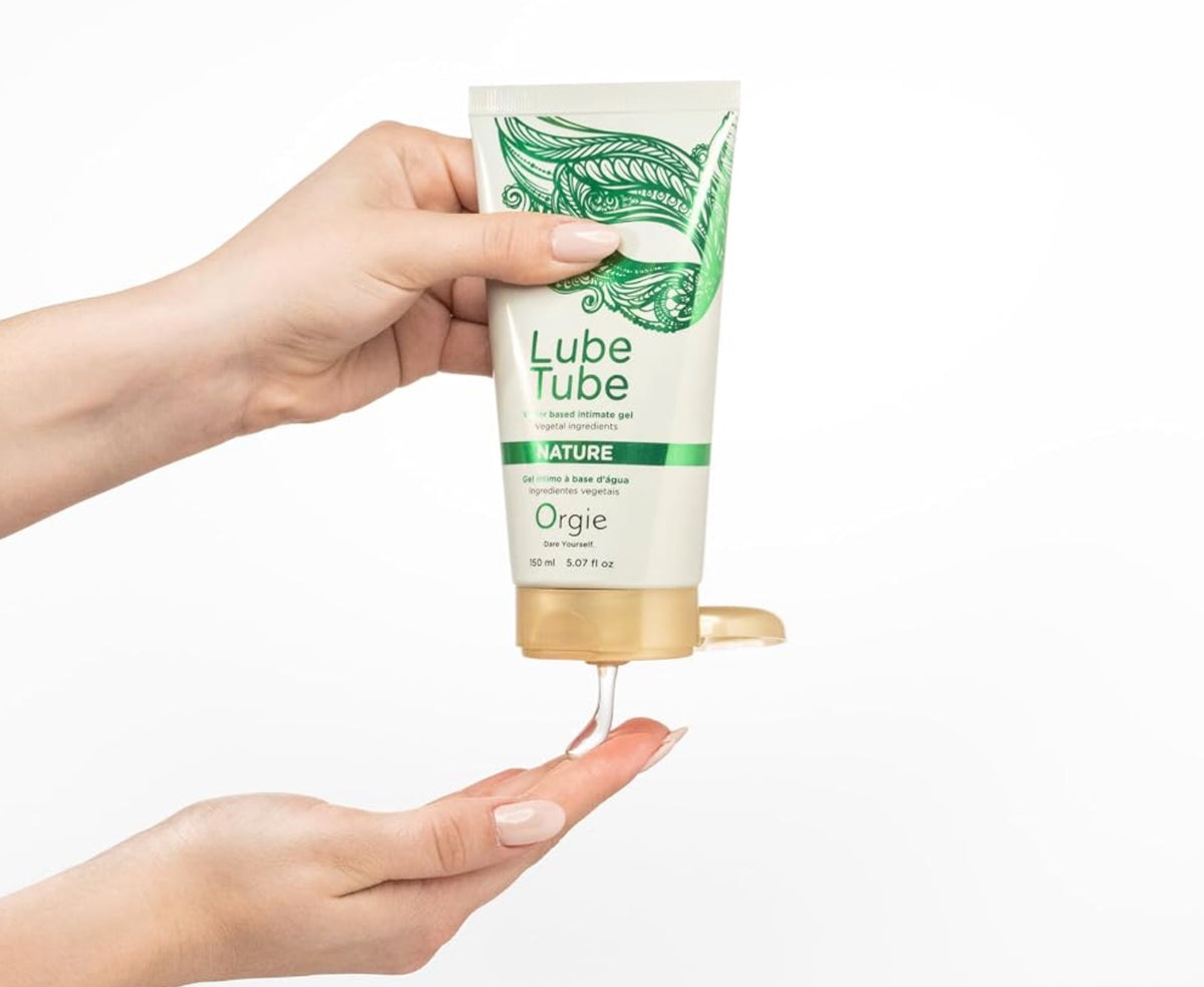 A hand squeezes a tube of Orgie Lube Tube water-based lubricant gel 